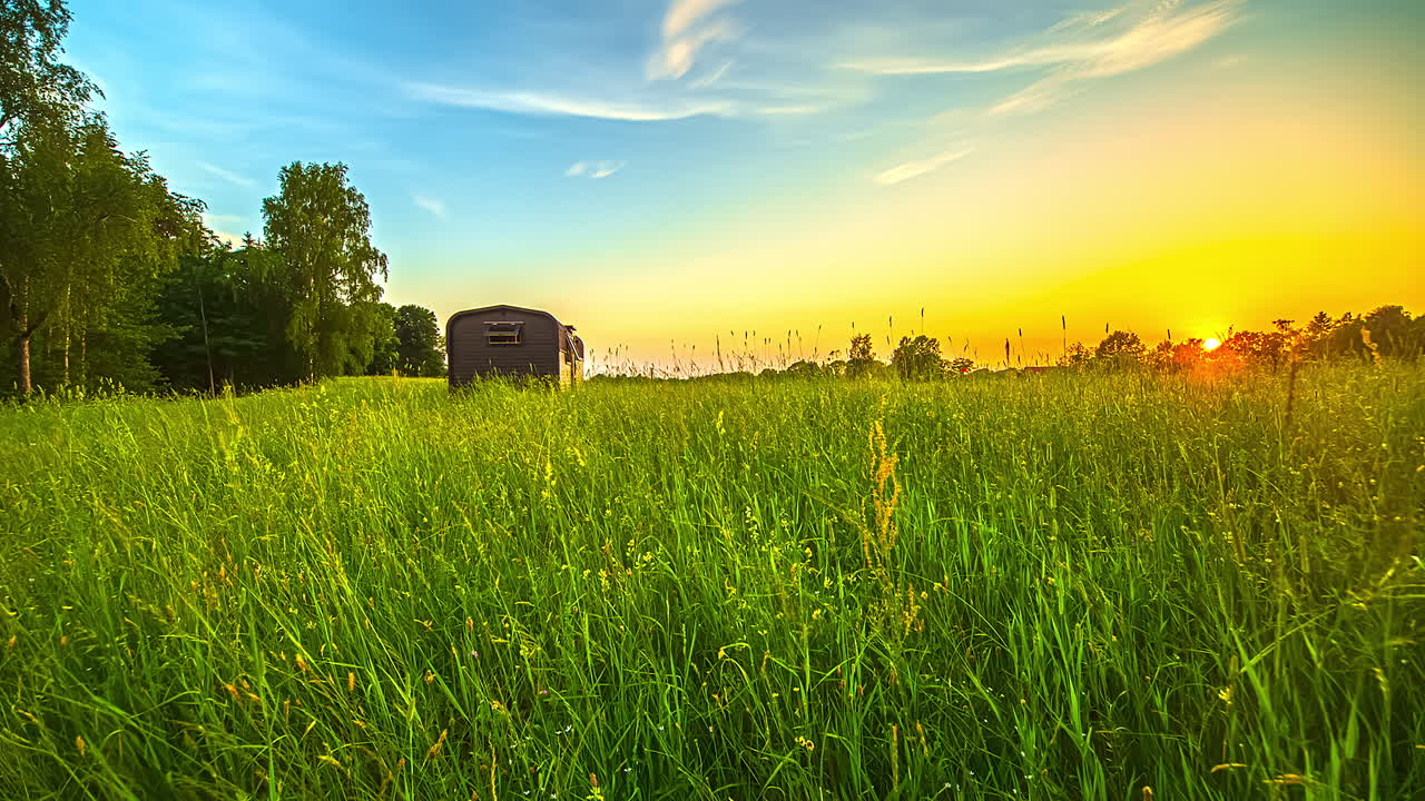 해질녘에 열목재를 사용한 작은 집 위에 아름다운 지평선