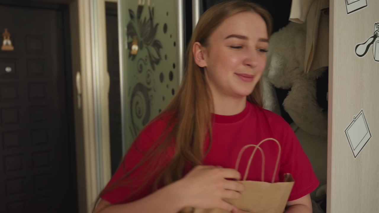 밝은 표정으로 옷장을 여는 금발 여성, 복도에서 쇼핑백을 들고 거울 옷장 문 근처에 있는 여성, 아파트 현관에서 미소로 자신을 맞이하는 캐주얼 복장의 백인 여성