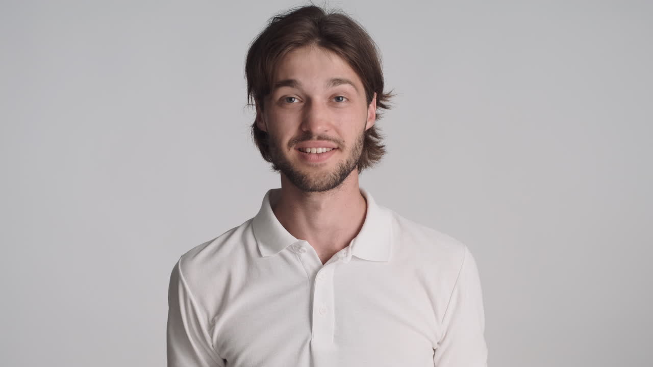 Caucasian happy man in front of camera on gray background.