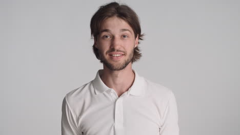 caucasian happy man in front of camera on gray background.