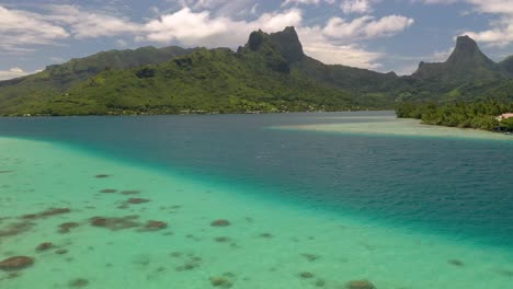 Aerial-shot-descending-over-the-barrier-reef-surrounding-Mo'orea,-a-beautiful-island-in-French-Polynesia