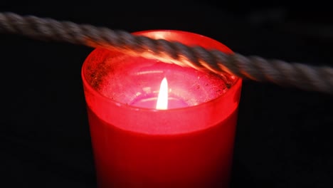 burning a jute rope on the fire of a candle for the shibari ritual