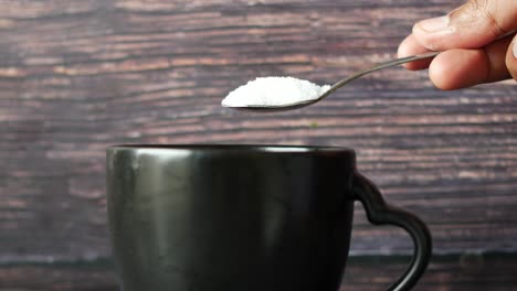 adding sugar to a drink