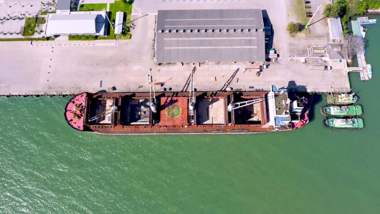 Aerial drone top view of containers cargo ship at industrial import-export port. Business logistic import and export freight transportation by container ship in open sea