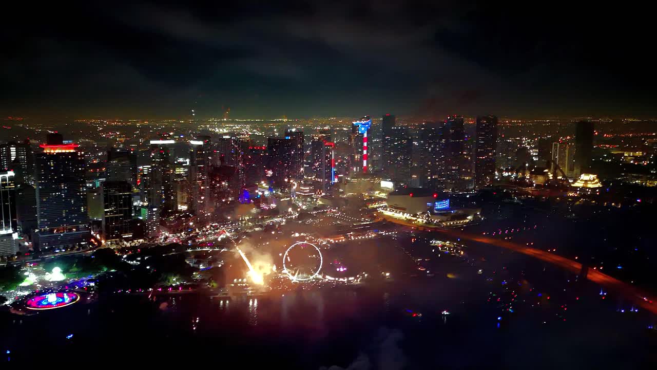 Colorful fireworks scatter across the night sky, captured from a soaring drone as shimmering lights enhance the breathtaking display