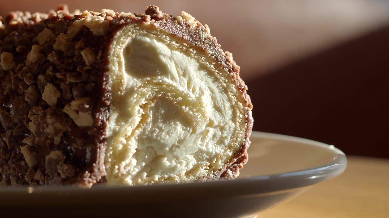 Appetizing Chocolate Roll Dessert with Creamy Filling and Crushed Nuts