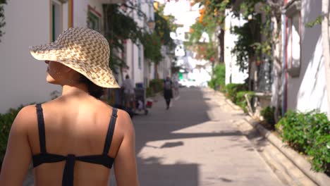 woman rear view walk through streets of white town old city in callao beach, gran canaria, canary islands, spain