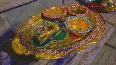 a gorgeous close-up of a golden plate with small miniature bowles, which is widely used in asian wedding traditions