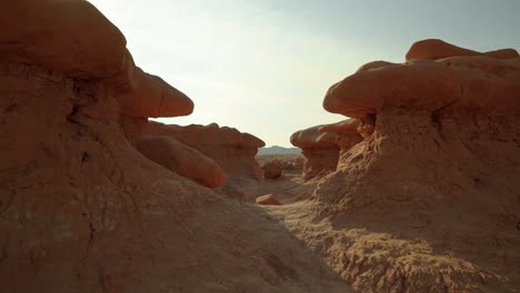 gorgeous stunning tilt up shot of the beautiful goblin valley utah state park mushroom rock formations with space to walk between them on a week on a warm sunny summer day