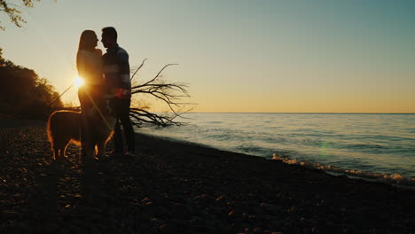 couple with dog at sunset