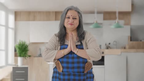 happy indian aged housewife doing namaste and greeting guests