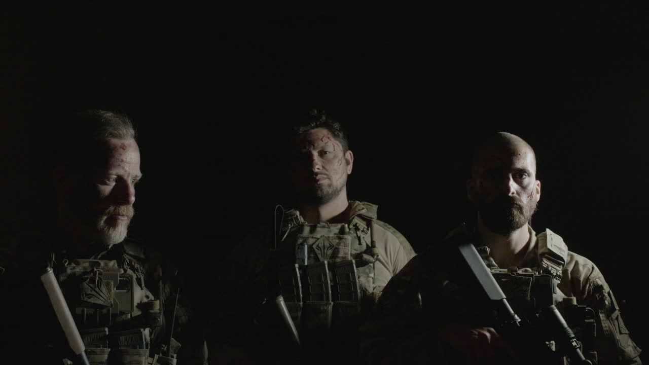 에어소프트 게임을 할 준비가 된 어두운 방에서 카메라를 위해 포즈를 취한 산탄총을 들고 있는 남자의 정면