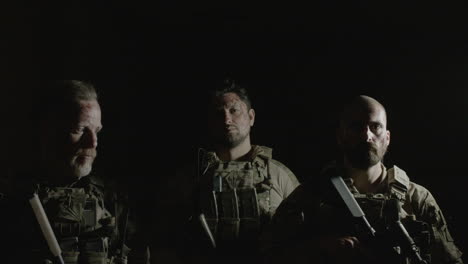 front view of men holding shotgun, posing for camera in a dark room ready to play airsoft