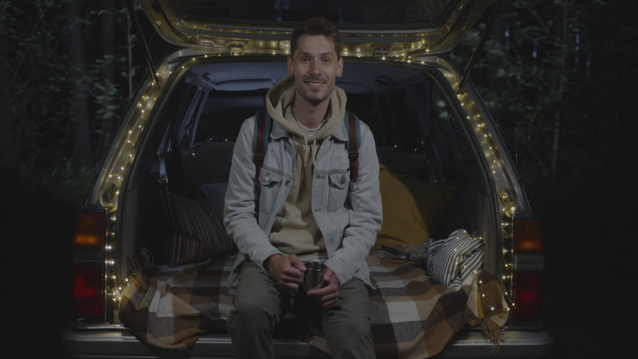 Man Relaxing in Car Trunk at Night
