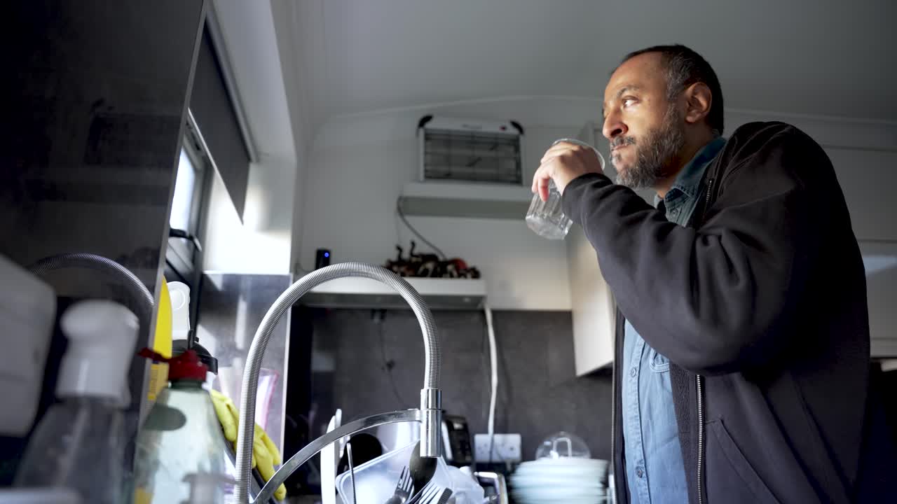 South Asian Man Drinking Water From Glass In Kitchen Hydration Thirst Refreshment Healthy Lifestyle Home Interior Wellbeing