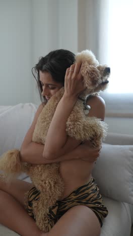 mujer acurrucando a un perro caniche