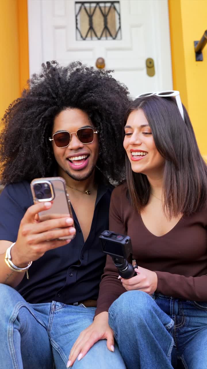 Couple laughing and taking photos on stairs