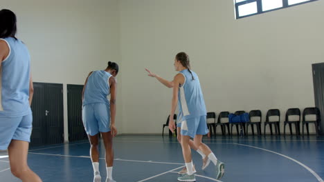 playing basketball, female athletes practicing on indoor court in sports uniforms
