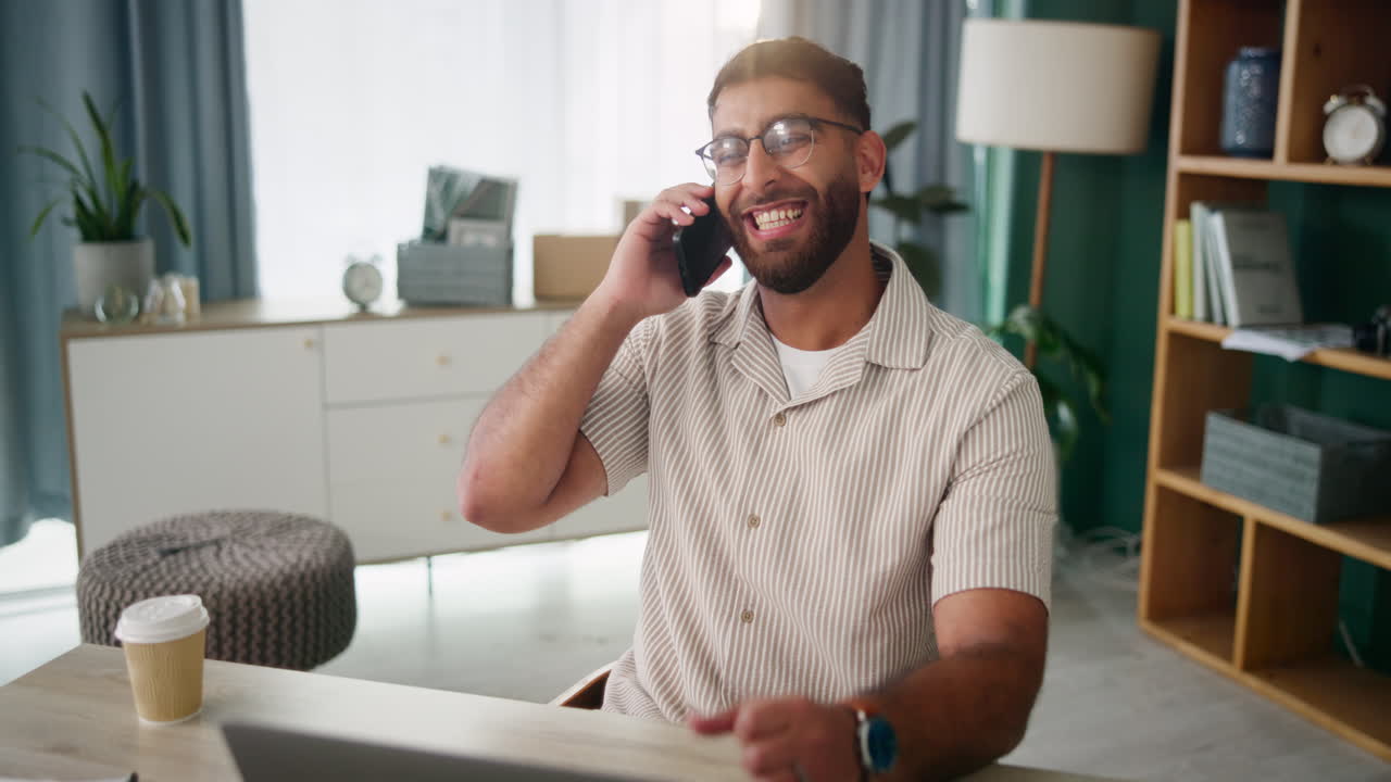 A man talking on the phone in his home office