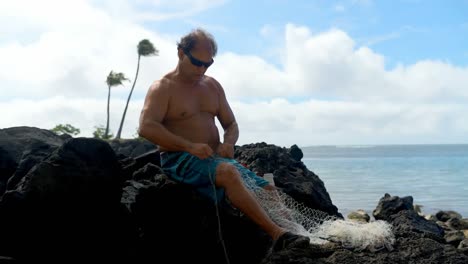 Fisherman-holding-fishing-net-in-the-beach-4k