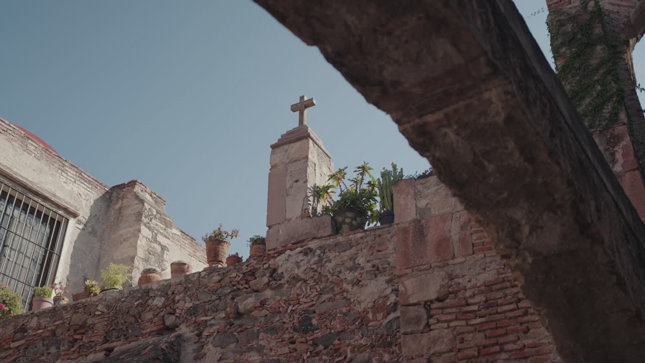 Old Stone Building with Cross and Plants