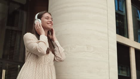 woman enjoying music by pillar outside