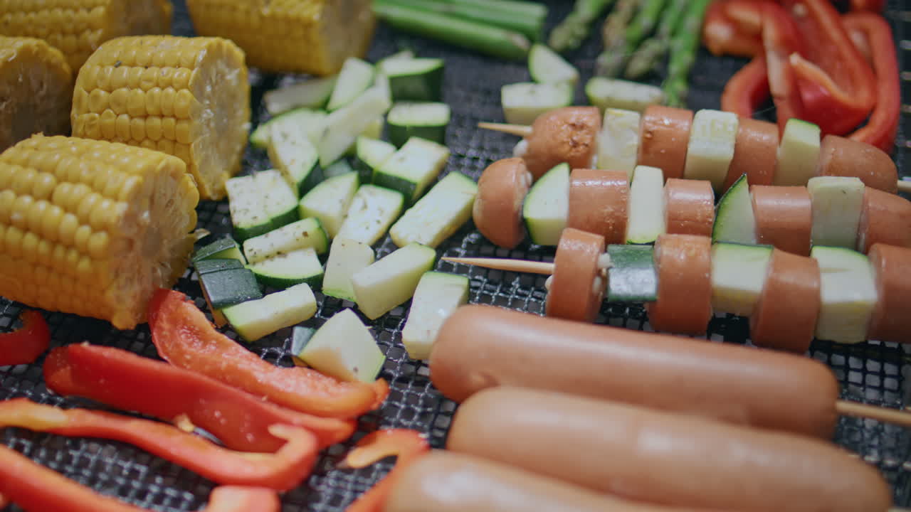 Closeup food grilling barbecue at summer picnic. Fresh vegetables and hotdogs
