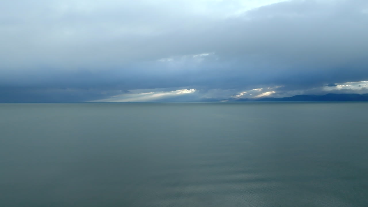 drone disparado volando sobre la bahía de tasmania océano hacia la costa al amanecer, nueva zelanda