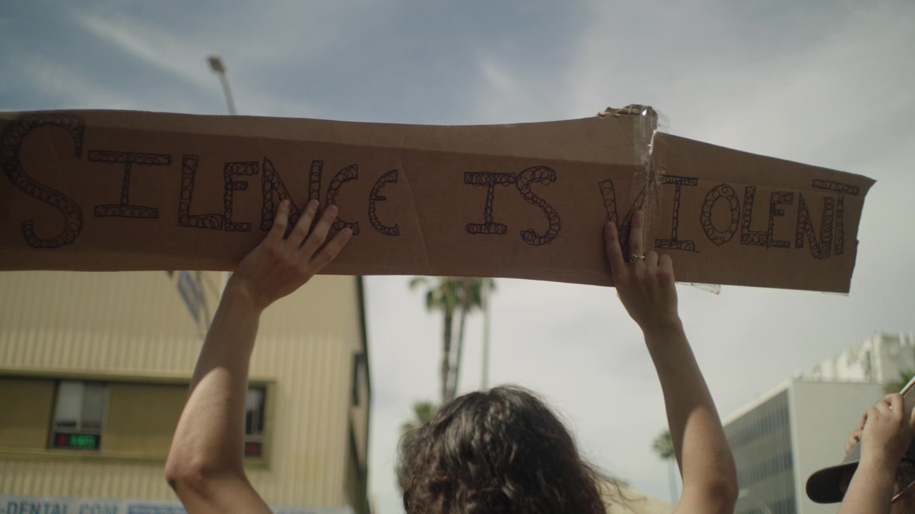 Women holding a sign during the day at a protest
