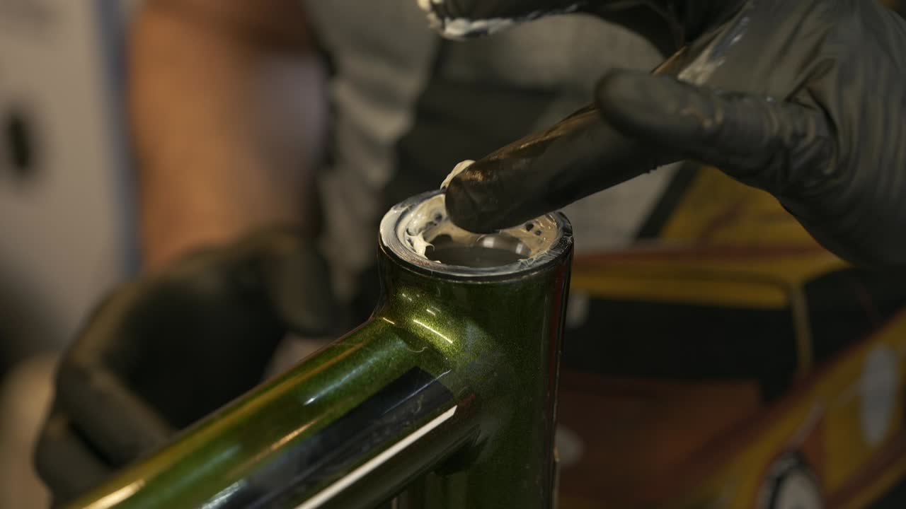 Grasso fresco viene applicato a un set di cuscinetti in una serie sterzo di bicicletta
