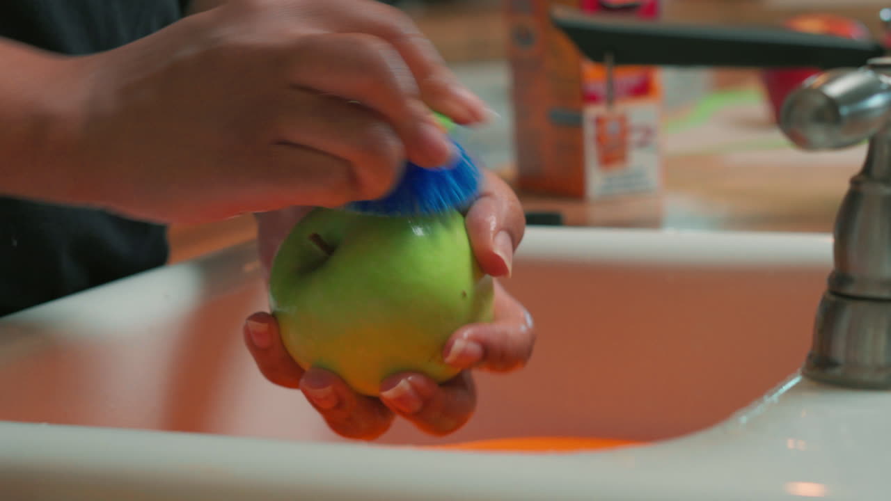 Limpiando bien una manzana verde para usarla en una receta casera o como tentempié