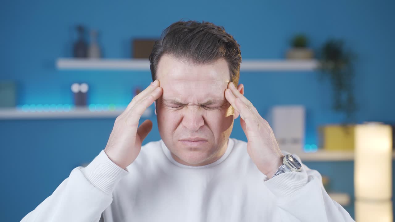 Man with headache is suffering and he doesn't like it at all. Migraine pain.
