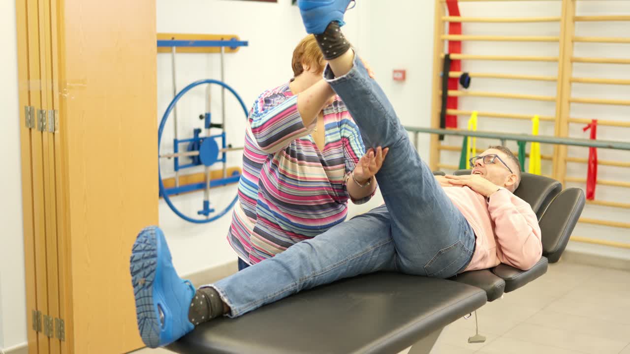 Hombre recibiendo fisioterapia en la pierna con una terapeuta.