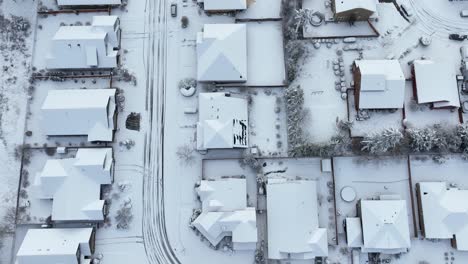 top down aerial view of a residential neighborhood covered in snow