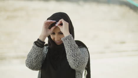 Young-muslim-woman-straightening-her-headscarf.