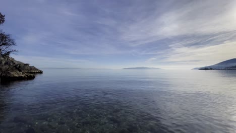 Pan-over-island-in-distance-on-shore,-Opatija,-Croatia