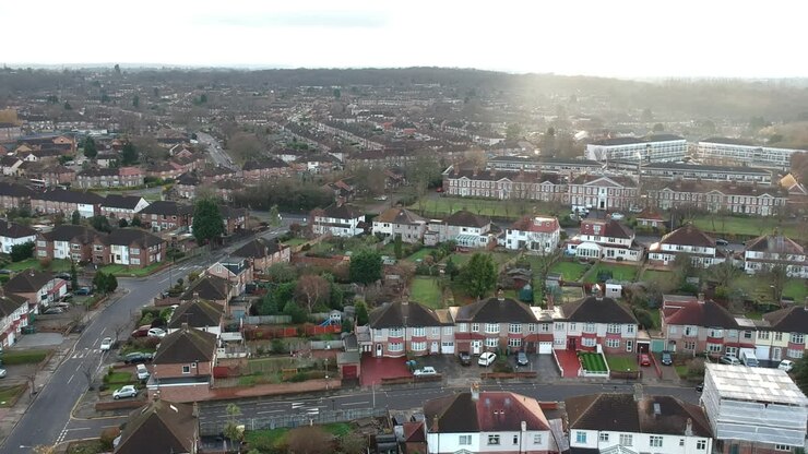 Drone View of Mottingham Suburbs in South East London: Quiet Neighborhood with Brown Tiled Terrace Houses and Well-Maintained Back Gardens