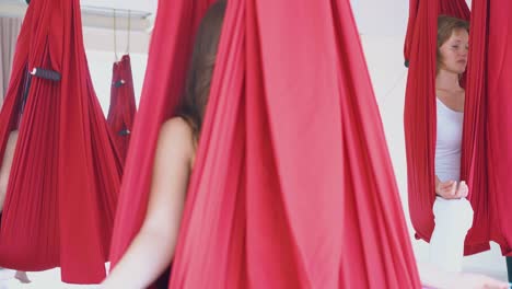 las mujeres se relajan en hamacas rojas con los dedos en posición mudra