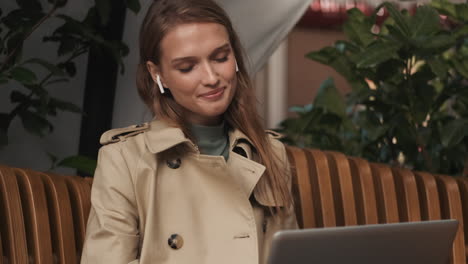 caucasian female video calling on laptop outdoors.