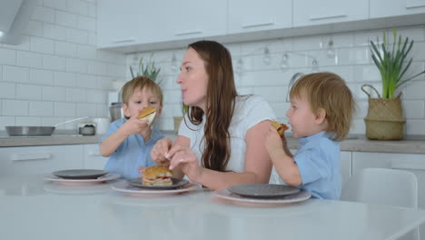 children in the kitchen feed their mom with self-cooked diet burgers