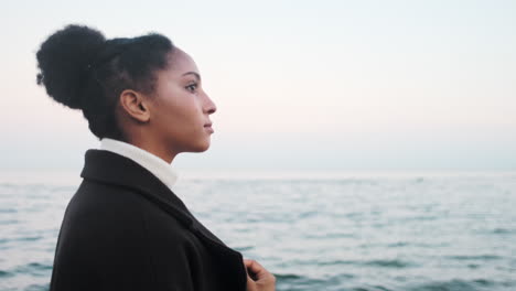 una chica afroamericana caminando por el mar.