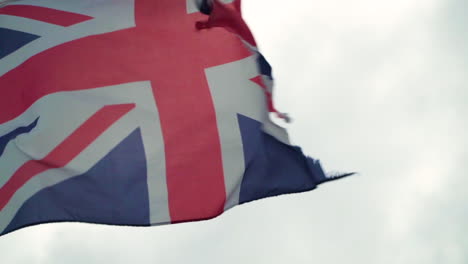 close up ruined british flag in strong winds in slow motion