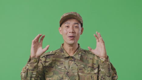 close up of asian man soldier smiling and saying wow while standing in the green screen background studio