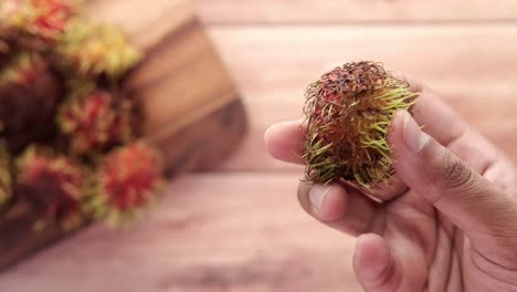 mano con una fruta de rambutan
