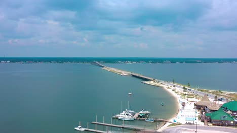 aerial view flying over navarre beach fl looking at the bridge going over the bay