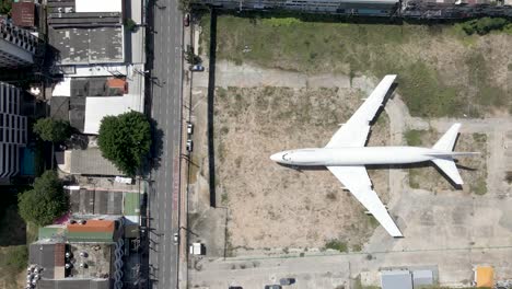 aterrizaje de emergencia de un avión blanco en medio de una ciudad, vuelo aéreo sobre un avión abandonado