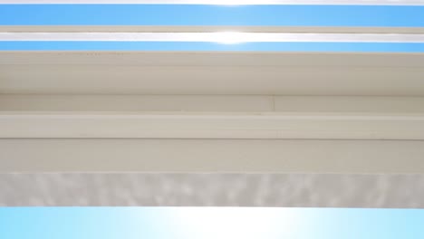 Slow-dolly-shot-of-the-sunlight-reflecting-on-the-patio-ceiling-on-a-villa