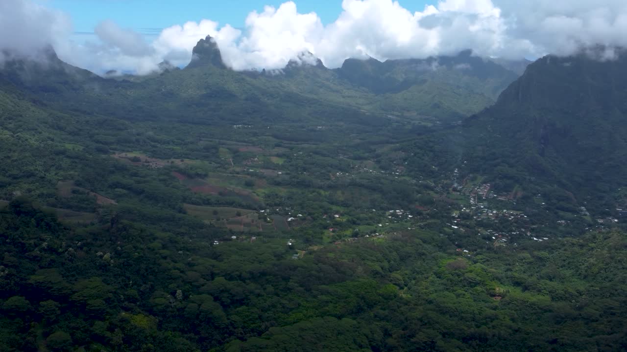 Drone view of mountains, forest and nature on a sunny day in a green tropical pacific island in Moorea, French Polynesia.