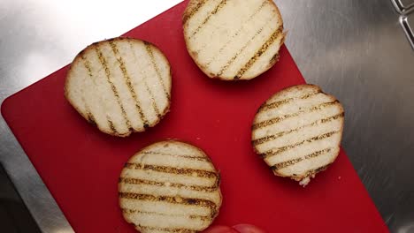 preparando panes de hamburguesa a la parrilla