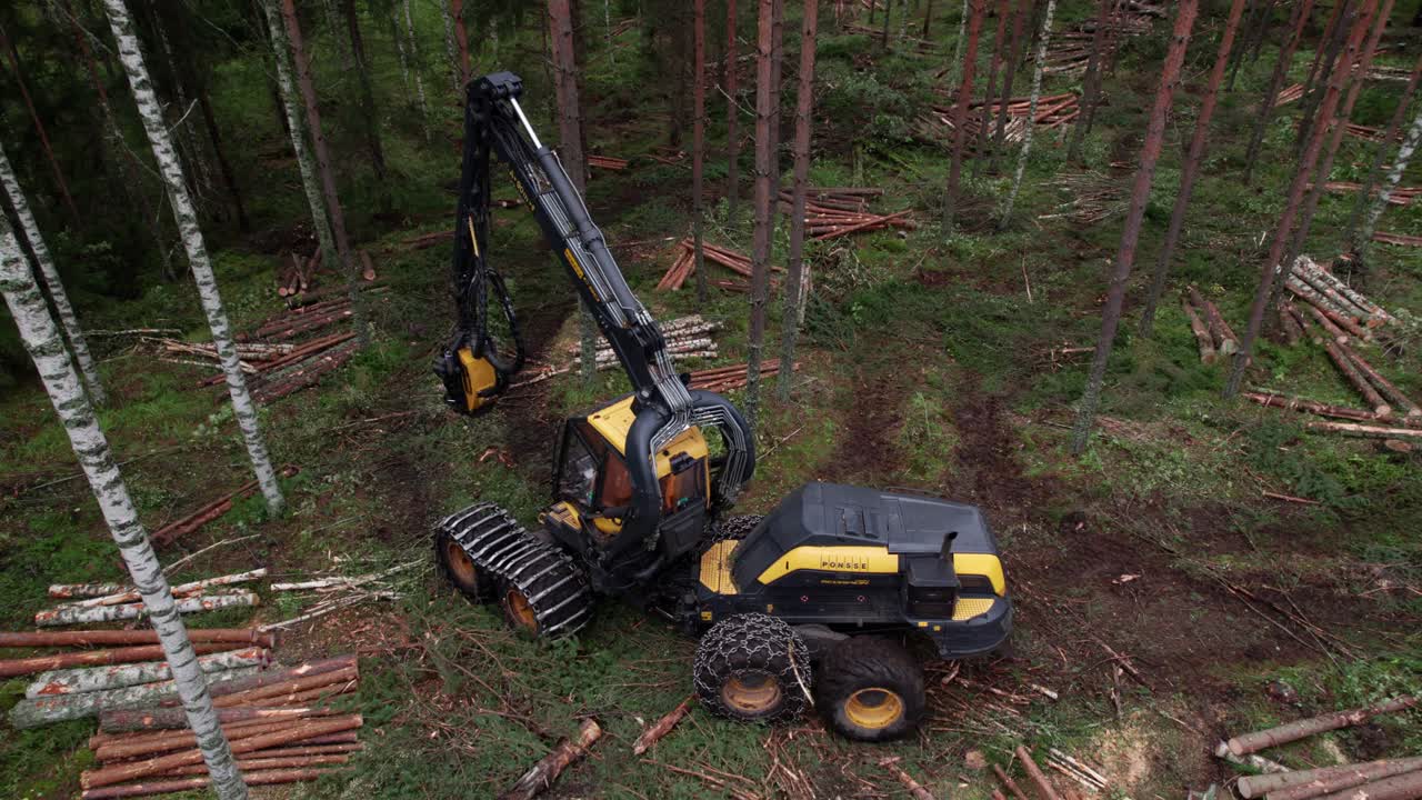 Aerial following shot of Scandinavian finnish forest and forestry machine Ponsse Scorpion harvester passing by, shot with DJI Air 2s